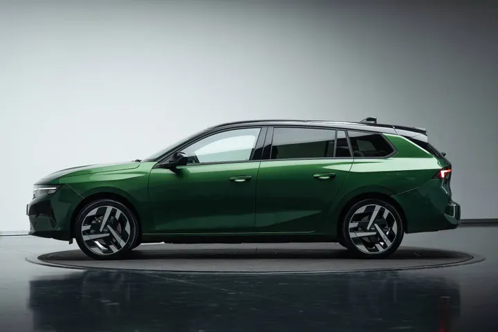 Vista laterale della Opel Astra 2026 Sports Tourer di colore verde con tetto nero e cerchi da 18 pollici dedicati all'allestimento GS