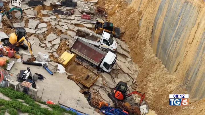 Foto della frana di Niscemi del gennaio 2026, con camion e furgoni in mezzo alle macerie di un cantiere