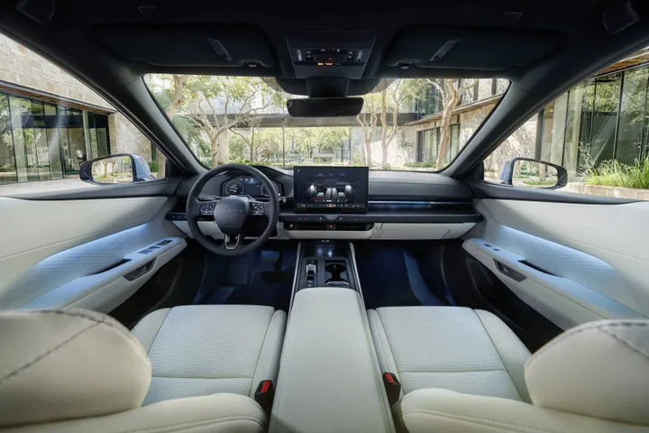 Interni della nuova berlina Lexus ES 2026: abitacolo spazioso con sedili chiari, plancia minimalista secondo la filosofia Clean Tech e ampio display digitale centrale