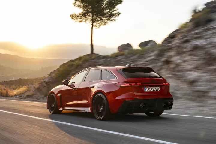 Nuova-Audi-RS5-2026 in posizione anteriore dinamica di colore rosso versione avant dinamica posteriore al tramonto su strada