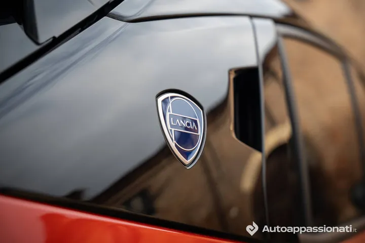 Lancia Ypsilon HF Line ibrida di colore arancione logo Lancia sul montante C in contrasto di colore nero