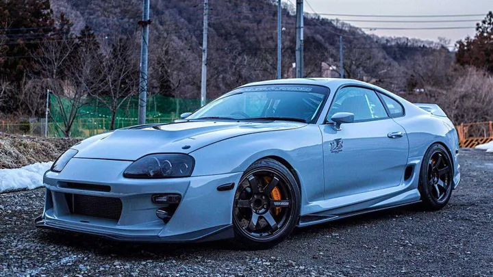 la foto ritrae una Toyota Supra MK4 leggermente modificata con uno sfondo collinare