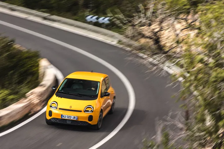 La nuova Renault Twingo 2026 IV E-Tech Giallo Mango impegnata in una curva ad alta velocità tra le strade di Ibiza&nbsp;