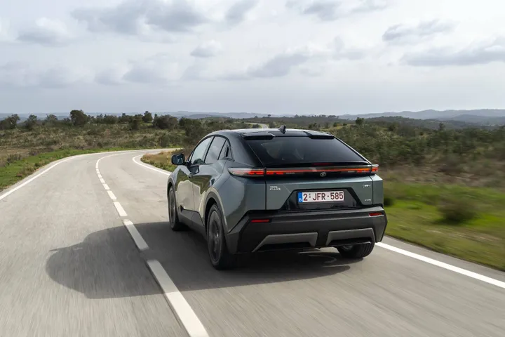 Il posteriore della Toyota C-HR+ 2026 impegnata in una curva di una strada statale tortuosa