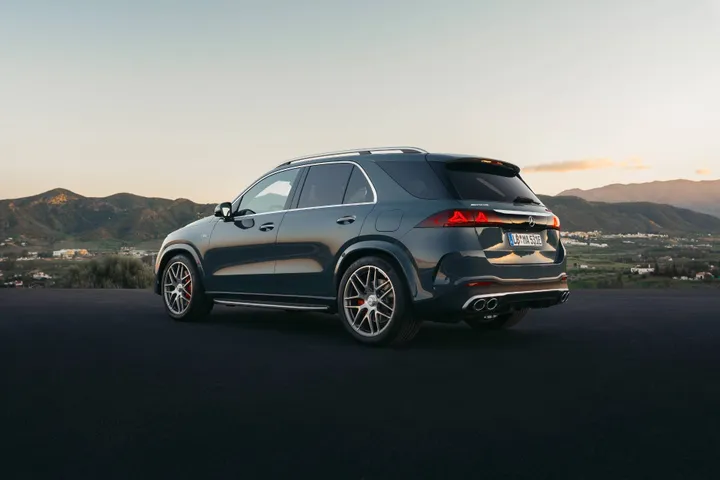 Mercedes GLE 2026 anteriore di colore verde versione 53 amg posteriore davanti a un tramonto