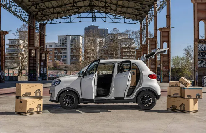 La leapmotor t03 van vista di lato con dei cartoni vicino e tutte le portiere aperte