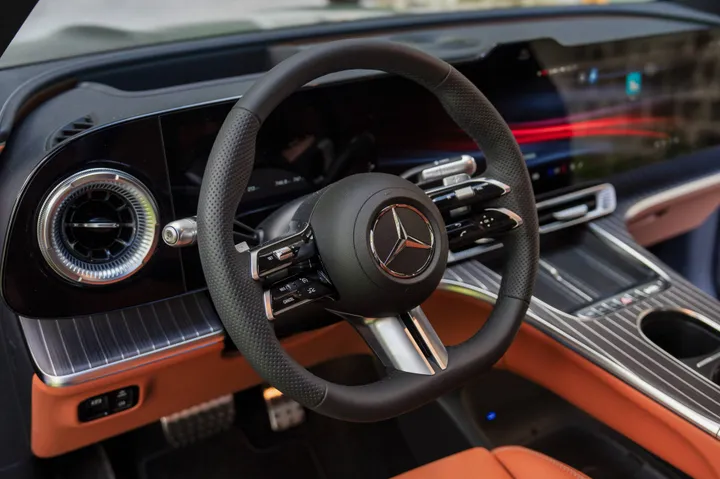 Volante GLC EQ in primo piano con pelle nera e color cuoio tre schermi sistema multimediale
