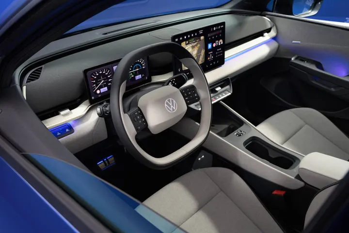 VW ID Polo di colore blu ripresa nella vista degli interni complessivi con volante e sedili in primo piano. Si vede anche la plancia con il display dell'infotainment