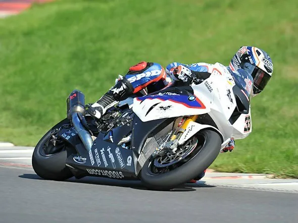 Stefano Nepa in sella ad una bici Protek accanto alla sua Mahindra MGP3O Moto3