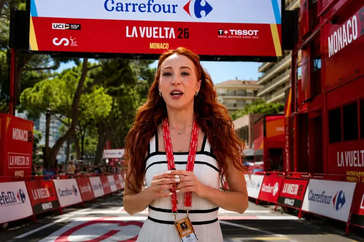 Erola Jons, the content creator hired by La Vuelta, waits for Tadej Pogacar at the team bus door