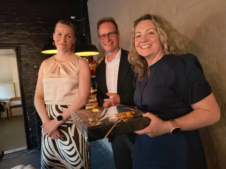 Ordfører Hilde Vollmerhaus mottar gave fra statsdirektør i Lohja Petra Ståhl og ststfullmäktig Niklas Koistinen