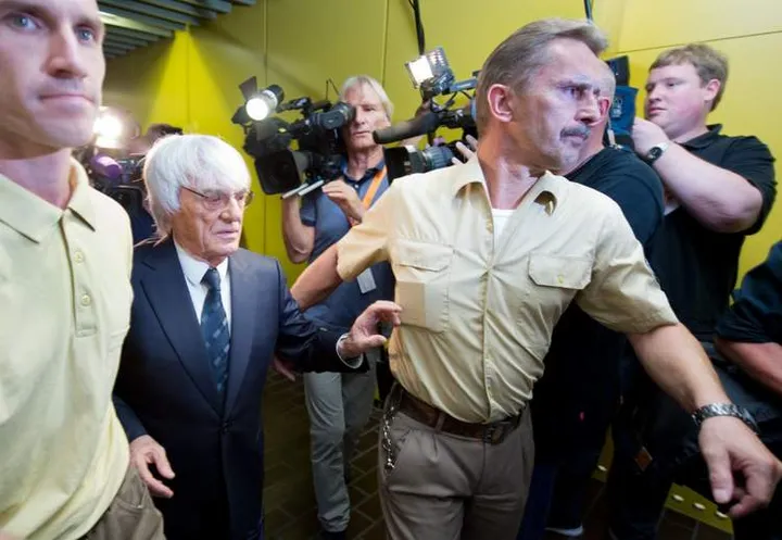 GERMANY OUT Formula One Chief Executive Bernie Ecclestone (2L) leaves the courtroom at the regional court in Munich, southern Germany, on August 5, 2014. The court ruled that Formula One tycoon Bernie Ecclestone may pay a $100-million settlement to end his trial on bribery charges. AFP PHOTO / DPA/PETER KNEFFEL GERMANY OUTPETER KNEFFEL/AFP/Getty Images