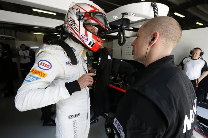Jenson Button talks with his engineer.
