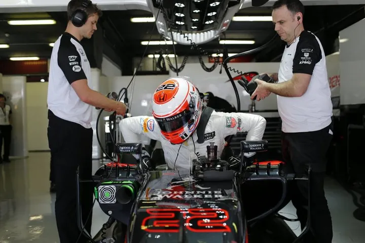 Jenson Button climbs from his car in the garage.