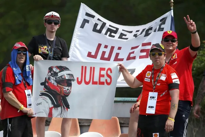 F1 supporters hold a banner in memoriam of former French Formula One driver Jules Bianchi during the first practice session of the Hungarian F1 Grand Prix at the Hungaroring circuit, near Budapest, Hungary July 24, 2015. The popular Bianchi died in hospital last Friday, nine months after his Marussia car slammed into a recovery tractor at the Japanese Grand Prix. REUTERS/Laszlo Balogh