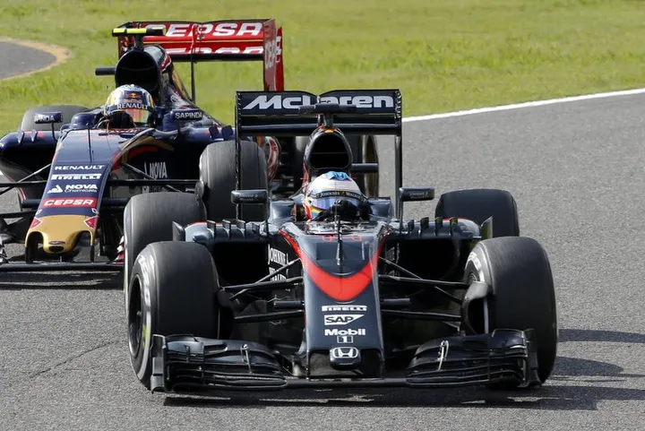 McLaren driver Fernando Alonso of Spain steers his car followed by Toro Rosso driver Carlos Sainz Jr. of Spain during the Japanese Formula One Grand Prix at the Suzuka Circuit in Suzuka, central Japan, Sunday, Sept. 27, 2015. (AP Photo/Shizuo Kambayashi) ORG XMIT: TTX153