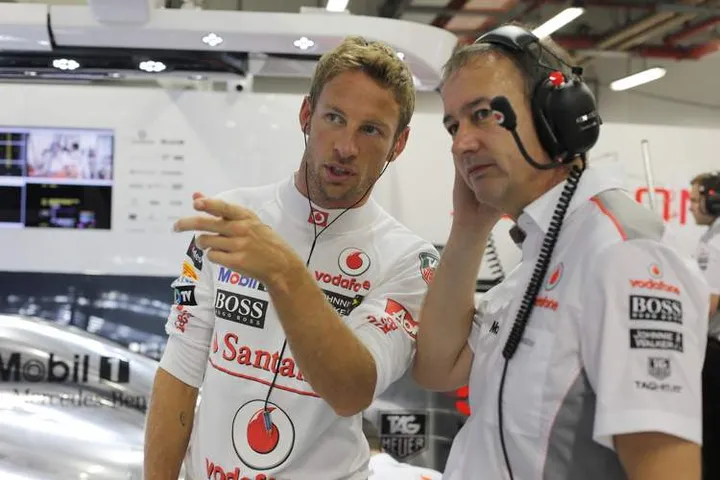 Jenson Button talks with Jonathan Neale, Managing Director in the garage.