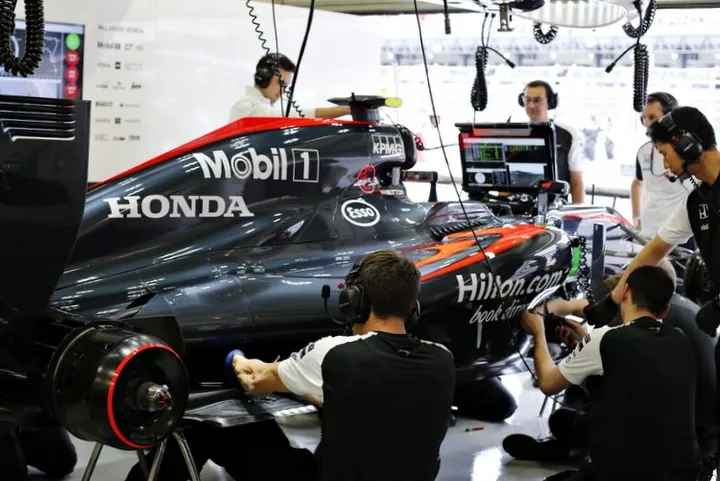 McLaren engineers work on the car of Jenson Button.