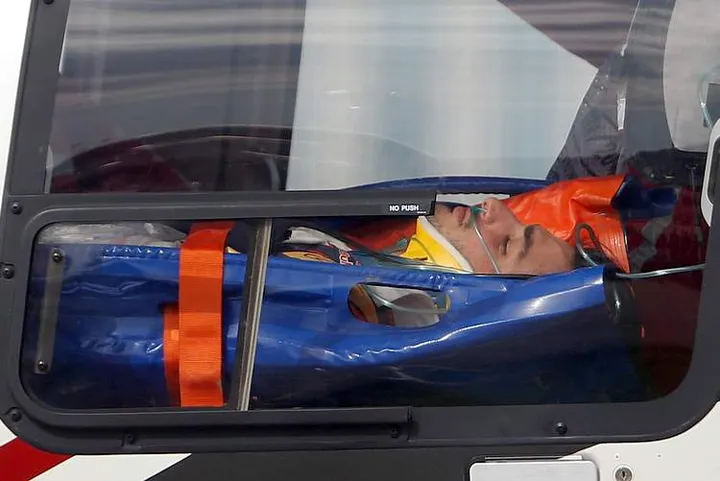 Toro Rosso driver Carlos Sainz Jr. of Spain, lies on a stretcher inside an helicopter to be transfer to a hospital, after crashing during the third free practice session at the 'Sochi Autodrom' Formula One track , in Sochi, Russia, Saturday, Oct. 10, 2015.  A heavy crash for Carlos Sainz Jr. ended the final practice session at the Russian Grand Prix on Saturday with the Toro Rosso driver hospitalized. The Formula one race will be held on Sunday. (AP Photo/Luca Bruno)