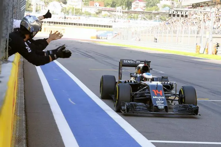 Team members congratulate Fernando Alonso on his sixth place finish.