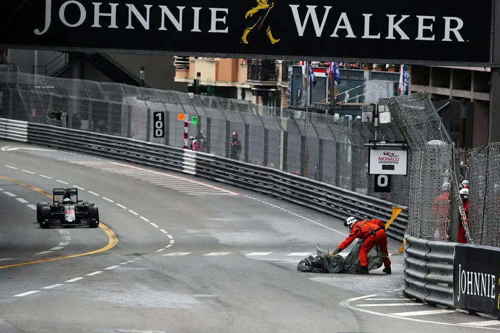 Monaco A marshal removes debris from the circuit.