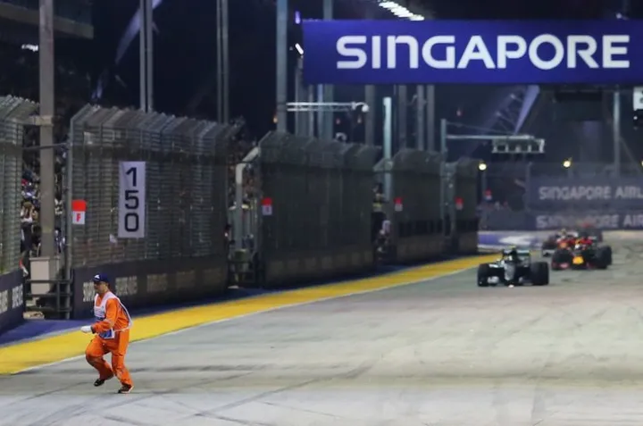 a-marshal-runs-along-the-circuit-as-nico-rosberg-mercedes-amg-f1-w07-hybrid-leads-at-the-restart1