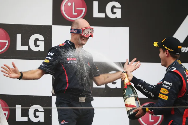 YEONGAM-GUN, SOUTH KOREA - OCTOBER 14: Red Bull Racing Chief Technical Officer Adrian Newey wears mechanics goggles to protect his eyes as race winner Sebastian Vettel of Germany and Red Bull Racing sprays champagne on the podium following the Korean Formula One Grand Prix at the Korea International Circuit on October 14, 2012 in Yeongam-gun, South Korea. (Photo by Mark Thompson/Getty Images) *** Local Caption *** Sebastian Vettel; Adrian Newey