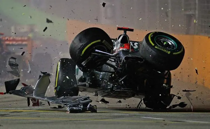 SINGAPORE - SEPTEMBER 23: Michael Schumacher of Germany and Mercedes GP crashes with Jean-Eric Vergne of France and Scuderia Toro Rosso during the Formula One Grand Prix of Singapore at Marina Bay Street Circuit on September 23, 2012 in Singapore. (Photo by Vladimir Rys/Getty Images)