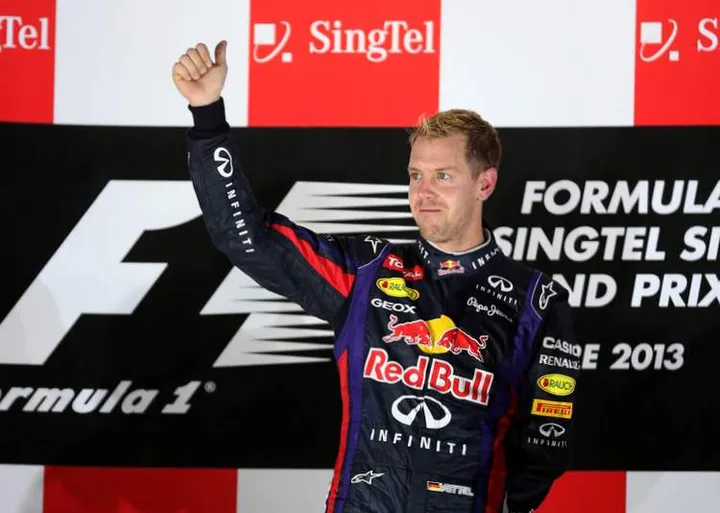 SINGAPORE - SEPTEMBER 22: Sebastian Vettel of Germany and Infiniti Red Bull racing celebrates following his victory during the Singapore Formula One Grand Prix at Marina Bay Street Circuit on September 22, 2013 in Singapore, Singapore. (Photo by Mark Thompson/Getty Images) *** Local Caption *** Sebastian Vettel