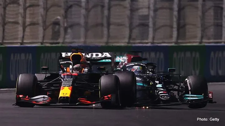JEDDAH, SAUDI ARABIA - DECEMBER 05: Max Verstappen of the Netherlands driving the (33) Red Bull Racing RB16B Honda and Lewis Hamilton of Great Britain driving the (44) Mercedes AMG Petronas F1 Team Mercedes W12 collide during the F1 Grand Prix of Saudi Arabia at Jeddah Corniche Circuit on December 05, 2021 in Jeddah, Saudi Arabia. (Photo by Lars Baron/Getty Images)
