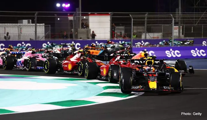 JEDDAH, SAUDI ARABIA - MARCH 27: Sergio Perez of Mexico driving the (11) Oracle Red Bull Racing RB18 leads Charles Leclerc of Monaco driving (16) the Ferrari F1-75 and the rest of the field at the start during the F1 Grand Prix of Saudi Arabia at the Jeddah Corniche Circuit on March 27, 2022 in Jeddah, Saudi Arabia. (Photo by Mark Thompson/Getty Images)