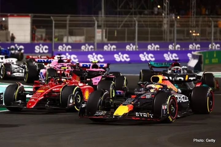 JEDDAH, SAUDI ARABIA - MARCH 27: Max Verstappen of the Netherlands driving the (1) Oracle Red Bull Racing RB18 and Carlos Sainz of Spain driving (55) the Ferrari F1-75 battle for track position at the start during the F1 Grand Prix of Saudi Arabia at the Jeddah Corniche Circuit on March 27, 2022 in Jeddah, Saudi Arabia. (Photo by Mark Thompson/Getty Images)