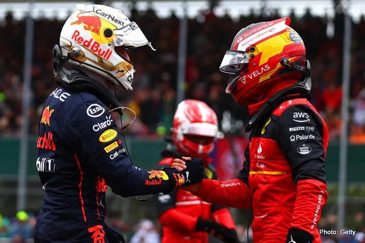 NORTHAMPTON, ENGLAND - JULY 02: Pole position qualifier Carlos Sainz of Spain and Ferrari is congratulated by Second placed qualifier Max Verstappen of the Netherlands and Oracle Red Bull Racing in parc ferme during qualifying ahead of the F1 Grand Prix of Great Britain at Silverstone on July 02, 2022 in Northampton, England. (Photo by Mark Thompson/Getty Images)