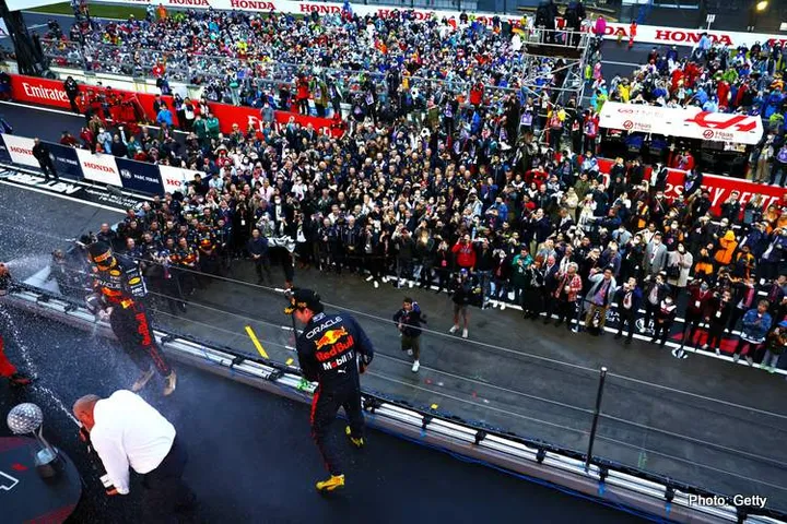 SUZUKA, JAPAN - OCTOBER 09: Race winner and 2022 F1 World Drivers Champion Max Verstappen of Netherlands and Oracle Red Bull Racing and Second placed Sergio Perez of Mexico and Oracle Red Bull Racing celebrate on the podium during the F1 Grand Prix of Japan at Suzuka International Racing Course on October 09, 2022 in Suzuka, Japan. (Photo by Mark Thompson/Getty Images )