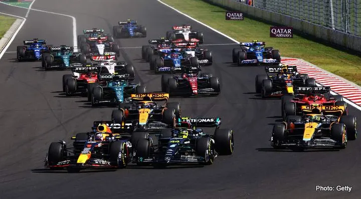 BUDAPEST, HUNGARY - JULY 23: Max Verstappen of the Netherlands driving the (1) Oracle Red Bull Racing RB19 leads Lewis Hamilton of Great Britain driving the (44) Mercedes AMG Petronas F1 Team W14 and the rest of the field into turn one at the start during the F1 Grand Prix of Hungary at Hungaroring on July 23, 2023 in Budapest, Hungary. (Photo by Mark Thompson/Getty Images)