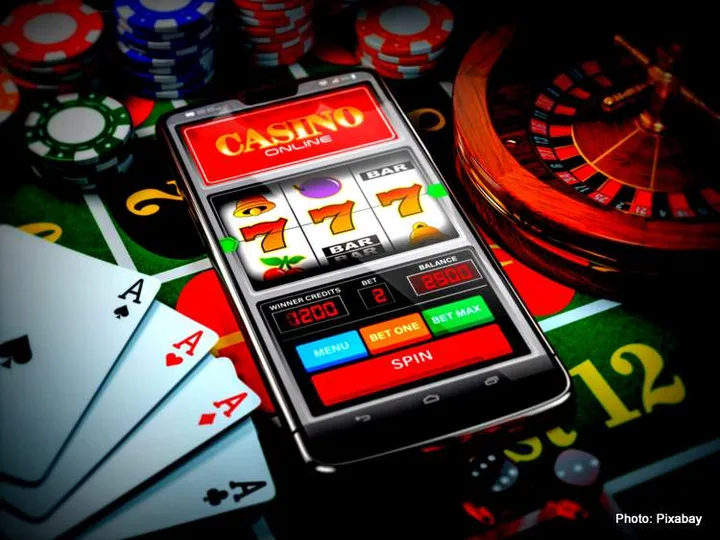 Casino online. Smartphone or mobile phone, slot machine, dice, cards and roulette on a green table in casino. 3d illustration / Weiterer Text über ots und www.presseportal.de/nr/165081 / Die Verwendung dieses Bildes für redaktionelle Zwecke ist unter Beachtung aller mitgeteilten Nutzungsbedingungen zulässig und dann auch honorarfrei. Veröffentlichung ausschließlich mit Bildrechte-Hinweis.