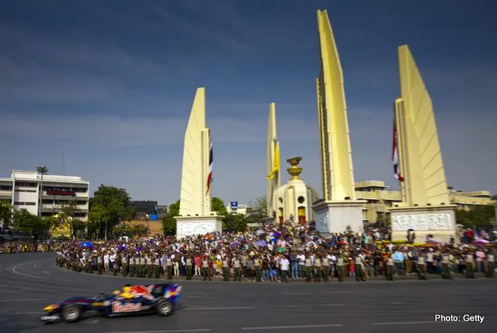 BANGKOK, THAILAND - DECEMBER 18:  Mark Webber of Australia drives his Red Bull RB6 Formula One car at Rajdamnoen Avenue during a Red Bull Street Kings on December 18, 2010 in Bangkok, Thailand. The event was a part of celebration ahead of the Thailand King Bhumibol Adulyadej's  83rd birthday.  (Photo by Athit Perawongmetha/Getty Images)
