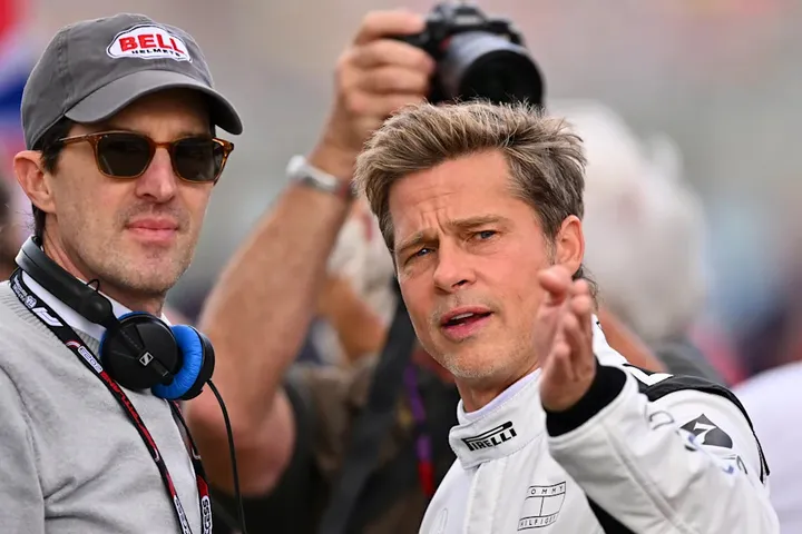 NORTHAMPTON, ENGLAND - JULY 09: Brad Pitt, star of the upcoming Formula One based movie, Apex, and Joseph Kosinski, director of the upcoming Formula One based movie, Apex, talk on the grid during the F1 Grand Prix of Great Britain at Silverstone Circuit on July 09, 2023 in Northampton, England. Verstappen not into Brad Pitt F1 movie