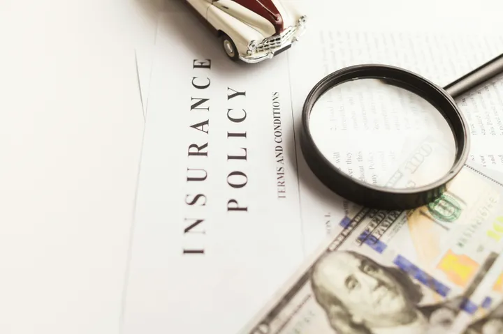 a magnifying glass sitting on top of a piece of paper insuraance