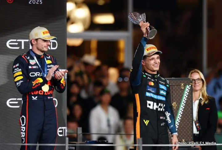 ABU DHABI, UNITED ARAB EMIRATES - DECEMBER 07: 2025 F1 World Drivers Champion and Third placed Lando Norris of Great Britain and McLaren celebrates on the podium as Race winner Max Verstappen of the Netherlands and Oracle Red Bull Racing looks on during the F1 Grand Prix of Abu Dhabi at Yas Marina Circuit on December 07, 2025 in Abu Dhabi, United Arab Emirates. (Photo by Zak Mauger/LAT Images)