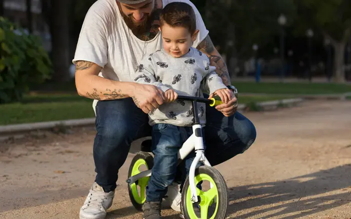 dad teaching kid to ride bike web