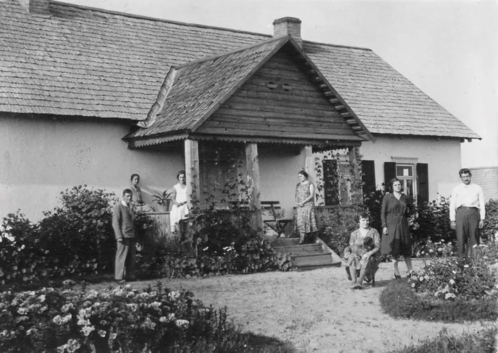 Felinas (pietinė dvarelio pusė, darželis). Verandoje – Veronika Savanevičiūtė, su šuneliu ant kelių sėdi Felicija, dešinėje prie gėlyno – Felicijos vyras Ipolitas Ramanauskas. Nežinomas fotografas, XX a. I-oji pusė