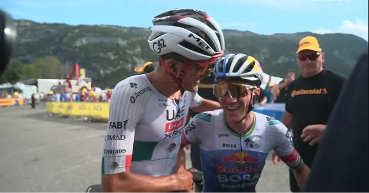 Remco Evenepoel und Isaac Del Toro lächeln und gratulieren sich im Ziel. Sekunden zuvor lieferten sie sich ein intensives Duell um den Sieg der 15. Etappe.