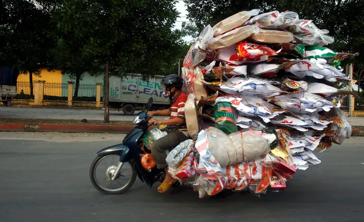 a man transports paper replicas of various items to be sold for the vu lan festival festival of hungry ghosts outside hanoi vietnam