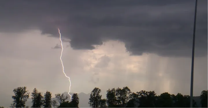Een onweer begeleidde het peloton over de dalwegen in de slotkilometers van de etappe.