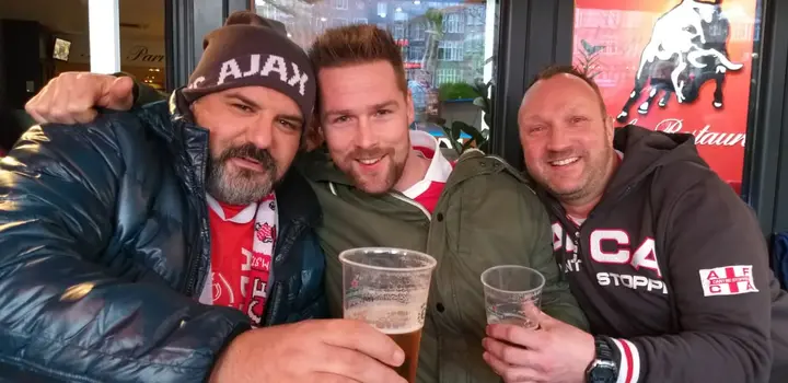 Tom (links) op de foto met twee Amsterdammers bij Café Monico voorafgaand aan een duel van Ajax.