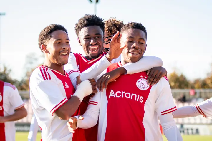 Chahine van Bohemen (links) en David Kalokoh vieren een doelpunt van Stanis Idumbo Muzambo met de Belgische smaakmaker.