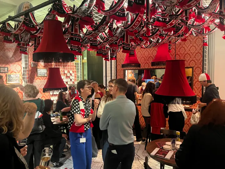 Bezoekers van de tentoonstelling lezen de teksten op de muren en praten over de Ajax-historie.