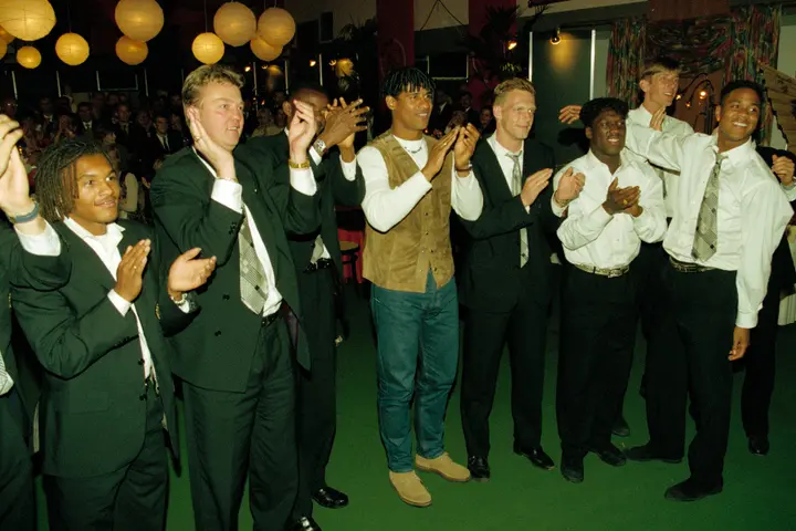 Enkele spelers van Ajax applaudisseren voor Karin Bloemen. Op de foto zien we onder meer Nordin Wooter, Louis van Gaal, Finidi George, Frank Rijkaard, Peter van Vossen, Clarence Seedorf, Edwin van der Sar en Patrick Kluivert.